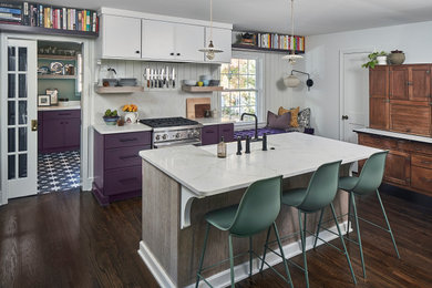 Example of a small eclectic dark wood floor and brown floor eat-in kitchen design in Charlotte with a farmhouse sink, recessed-panel cabinets, purple cabinets, quartz countertops, white backsplash, quartz backsplash, stainless steel appliances, an island and yellow countertops
