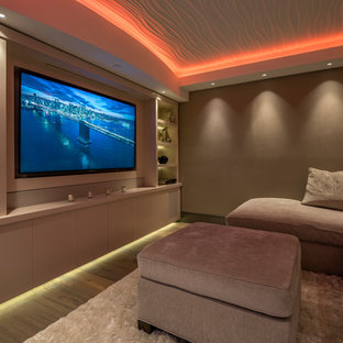 Photo of a contemporary home cinema in Miami with beige walls, medium hardwood flooring and a built-in media unit.