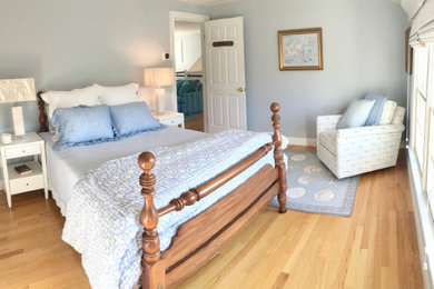 ボストンにあるビーチスタイルのおしゃれな客用寝室 (青い壁、淡色無垢フローリング、茶色い床) のレイアウト