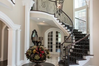 Example of a huge classic marble floor and white floor entryway design in Other with beige walls and a dark wood front door