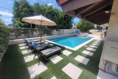Large minimalist backyard concrete paver and rectangular natural pool landscaping photo in Orange County