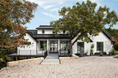 Mid-sized country white one-story concrete fiberboard and board and batten exterior home photo in Austin with a metal roof and a black roof