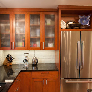 Glass doors reduce impact of cheery cabinets, display area above fridge