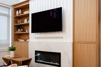 Example of a small transitional open concept laminate floor and gray floor living room design in Vancouver with a standard fireplace, a stone fireplace and a media wall