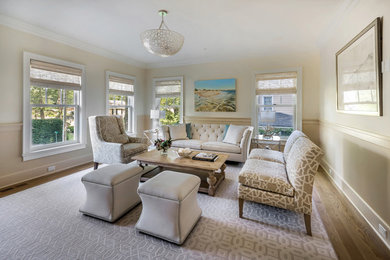 Example of a classic enclosed medium tone wood floor and brown floor living room design in New York with beige walls