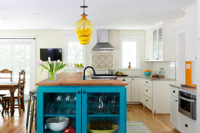 Inspiration for a large transitional medium tone wood floor kitchen remodel in DC Metro with white cabinets, stainless steel appliances and an island