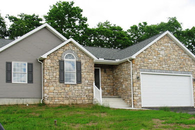 Example of a mid-sized arts and crafts gray one-story concrete exterior home design in Other with a clipped gable roof