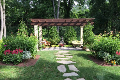 Design ideas for a large traditional backyard patio in New York with natural stone pavers and a pergola.