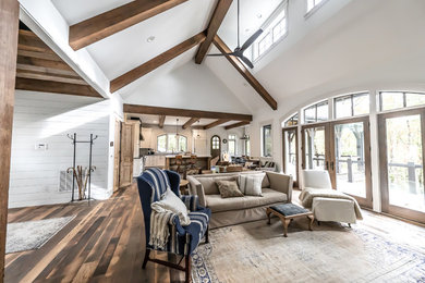 Farmhouse medium tone wood floor living room photo in Other with white walls
