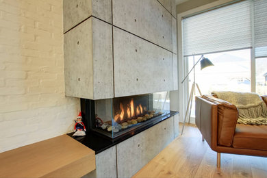 エドモントンにある中くらいなミッドセンチュリースタイルのおしゃれなLDK (白い壁、淡色無垢フローリング、横長型暖炉、コンクリートの暖炉まわり、ベージュの床、レンガ壁) の写真
