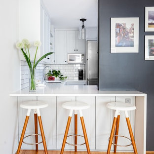 Выдающиеся фото от архитекторов и дизайнеров интерьера: маленькая п-образная кухня в современном стиле с врезной раковиной, фасадами в стиле шейкер, белым фартуком, фартуком из плитки кабанчик, техникой из нержавеющей стали, белой столешницей, серыми фасадами, столешницей из кварцевого композита и черным полом