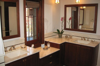 Example of a master bathroom design in Chicago with an undermount sink, recessed-panel cabinets, dark wood cabinets, marble countertops, a one-piece toilet and white walls