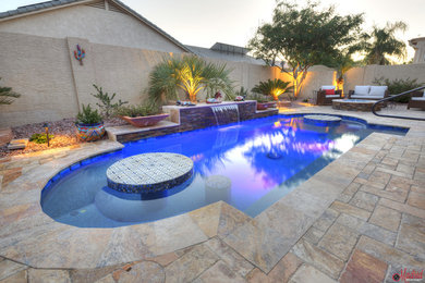 Design ideas for a small backyard custom-shaped pool in Phoenix with a water feature.