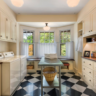 Photo of a medium sized traditional galley separated utility room in Philadelphia with beaded cabinets, beige cabinets, wood worktops, beige walls, painted wood flooring, a side by side washer and dryer and brown worktops.