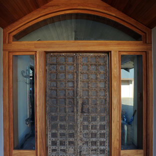 Large eclectic front door in Wollongong with concrete floors, a pivot front door and a dark wood front door.
