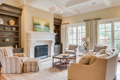 This is an example of an expansive transitional formal open concept living room in Charlotte with beige walls, medium hardwood floors, a standard fireplace, a wood fireplace surround and no tv.