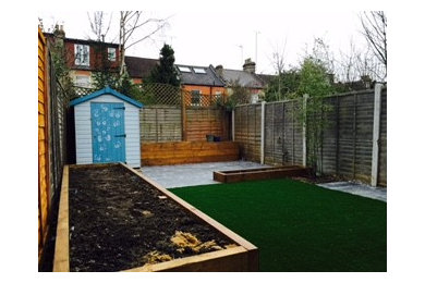 Freshly laid turf with timber stained beds & slate paving