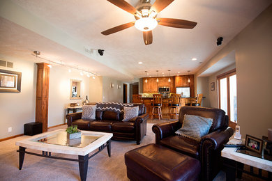 Mid-sized elegant walk-out carpeted and gray floor basement photo in Omaha with beige walls, a corner fireplace and a stone fireplace