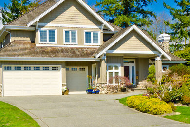 Inspiration for a large beige two-story stone exterior home remodel in Vancouver