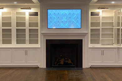 Modelo de salón cerrado actual con paredes blancas, suelo de madera oscura y televisor colgado en la pared