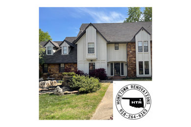White two-story wood and board and batten house exterior idea in Other