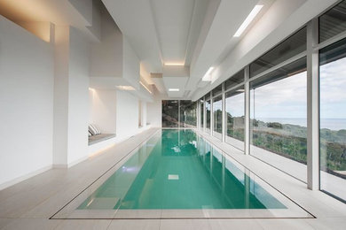 Inspiration for a large contemporary indoor rectangular pool in Melbourne with a pool house and tile.