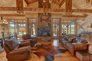 Example of a large country open concept brown floor and exposed beam living room design in Other with beige walls, a standard fireplace and a brick fireplace