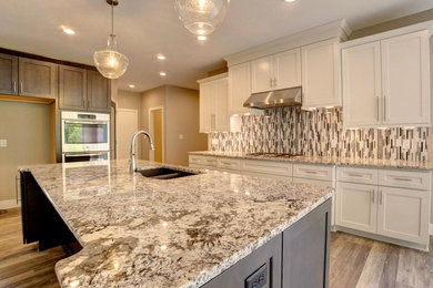 Large trendy u-shaped medium tone wood floor and brown floor open concept kitchen photo in Chicago with a double-bowl sink, shaker cabinets, beige cabinets, granite countertops, beige backsplash, matchstick tile backsplash, stainless steel appliances and an island