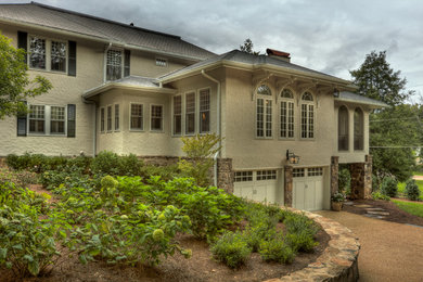 Mid-sized transitional beige two-story stucco exterior home photo in Other with a hip roof