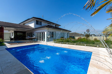 Photo of a small contemporary backyard rectangular pool in Newcastle - Maitland with a water feature and natural stone pavers.