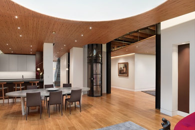 Example of a mid-sized minimalist medium tone wood floor and brown floor kitchen/dining room combo design in San Francisco with white walls and no fireplace