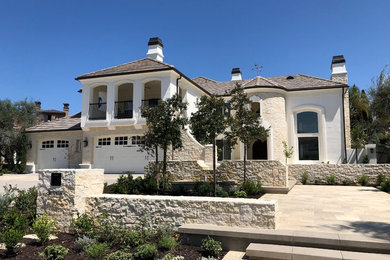 Inspiration for a large mediterranean white two-story mixed siding house exterior remodel in Orange County