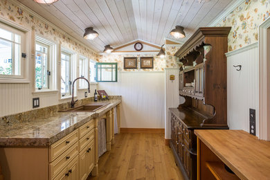 Small country galley separate kitchen in Seattle with a drop-in sink, raised-panel cabinets, distressed cabinets, granite benchtops and a peninsula.