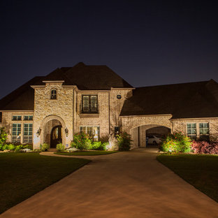 Новые идеи обустройства дома: двухэтажный фасад дома среднего размера бежевого цвета в классическом стиле с облицовкой из камня и полувальмовой крышей