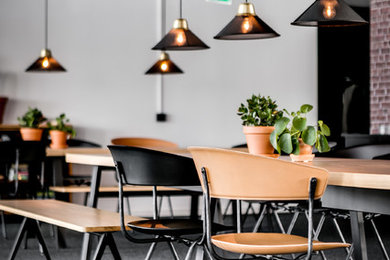 Industrial Arbeitszimmer mit weißer Wandfarbe, Teppichboden, freistehendem Schreibtisch und grauem Boden in Stockholm