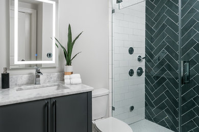 Alcove shower - mid-sized modern 3/4 black and white tile and slate tile porcelain tile and white floor alcove shower idea with flat-panel cabinets, black cabinets, a one-piece toilet, gray walls, an undermount sink, quartz countertops, a hinged shower door and white countertops