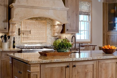 Inspiration for a traditional open plan kitchen in Los Angeles with a single-bowl sink, shaker cabinets, medium wood cabinets, granite benchtops, beige splashback, stone tile splashback, stainless steel appliances, travertine floors and with island.