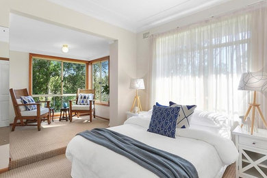 Small beach style master bedroom in Sydney with beige walls, carpet and beige floor.