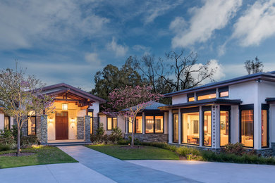 Expansive modern one-storey stucco white house exterior in San Diego with a gable roof and a shingle roof.