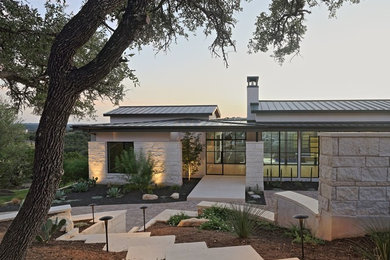 Inspiration for a large contemporary white two-story stone exterior home remodel in Austin with a metal roof