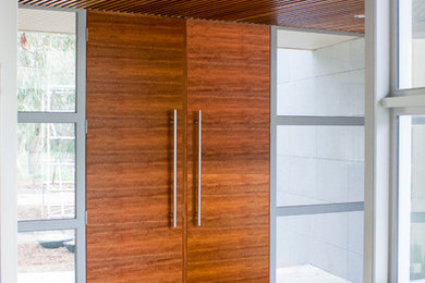 This is an example of a mid-sized contemporary entryway in Melbourne with a double front door and a medium wood front door.