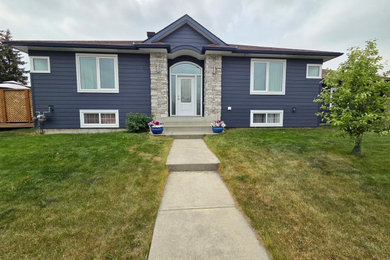 Inspiration for a large transitional blue split-level concrete fiberboard and clapboard house exterior remodel in Calgary