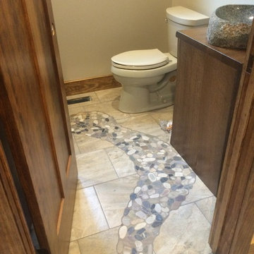 River rock mosaic tile inlay bath floor leads to shower