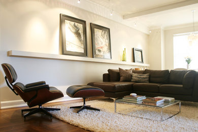Example of a mid-sized mid-century modern open concept medium tone wood floor living room design in New York with white walls