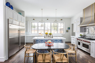 Transitional dark wood floor eat-in kitchen photo in Houston with shaker cabinets, white cabinets, stainless steel appliances and an island