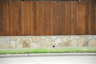 Inspiration for a mid-sized traditional full sun side yard stone retaining wall landscape in Dallas.