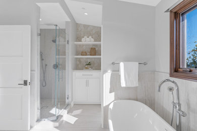 Inspiration for a mid-sized coastal master brown tile and marble tile marble floor, beige floor, double-sink and wainscoting bathroom remodel in Orange County with shaker cabinets, white cabinets, a one-piece toilet, white walls, an undermount sink, quartz countertops, a hinged shower door, white countertops and a built-in vanity