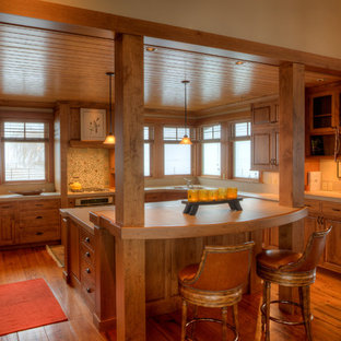 Réalisation d'une arrière-cuisine champêtre en U de taille moyenne avec un évier encastré, un placard avec porte à panneau surélevé, des portes de placard marrons, un plan de travail en carrelage, une crédence beige, une crédence en carreau de porcelaine, un sol en bois brun, un îlot central, un plan de travail beige et un électroménager encastrable.