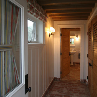 Klassisk inredning av en liten hall, med vita väggar och tegelgolv