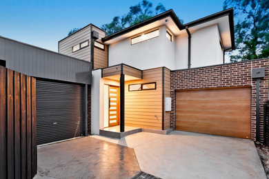 This is an example of a large modern white townhouse exterior in Melbourne.
